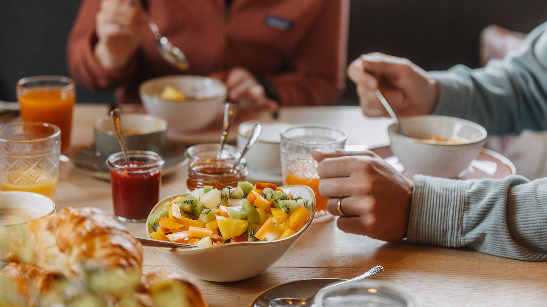 Ihr Bed and Breakfast in Lech am Arlberg Frühstückstisch mit frischem Obstsalat, Croissants, Säften und zwei Personen